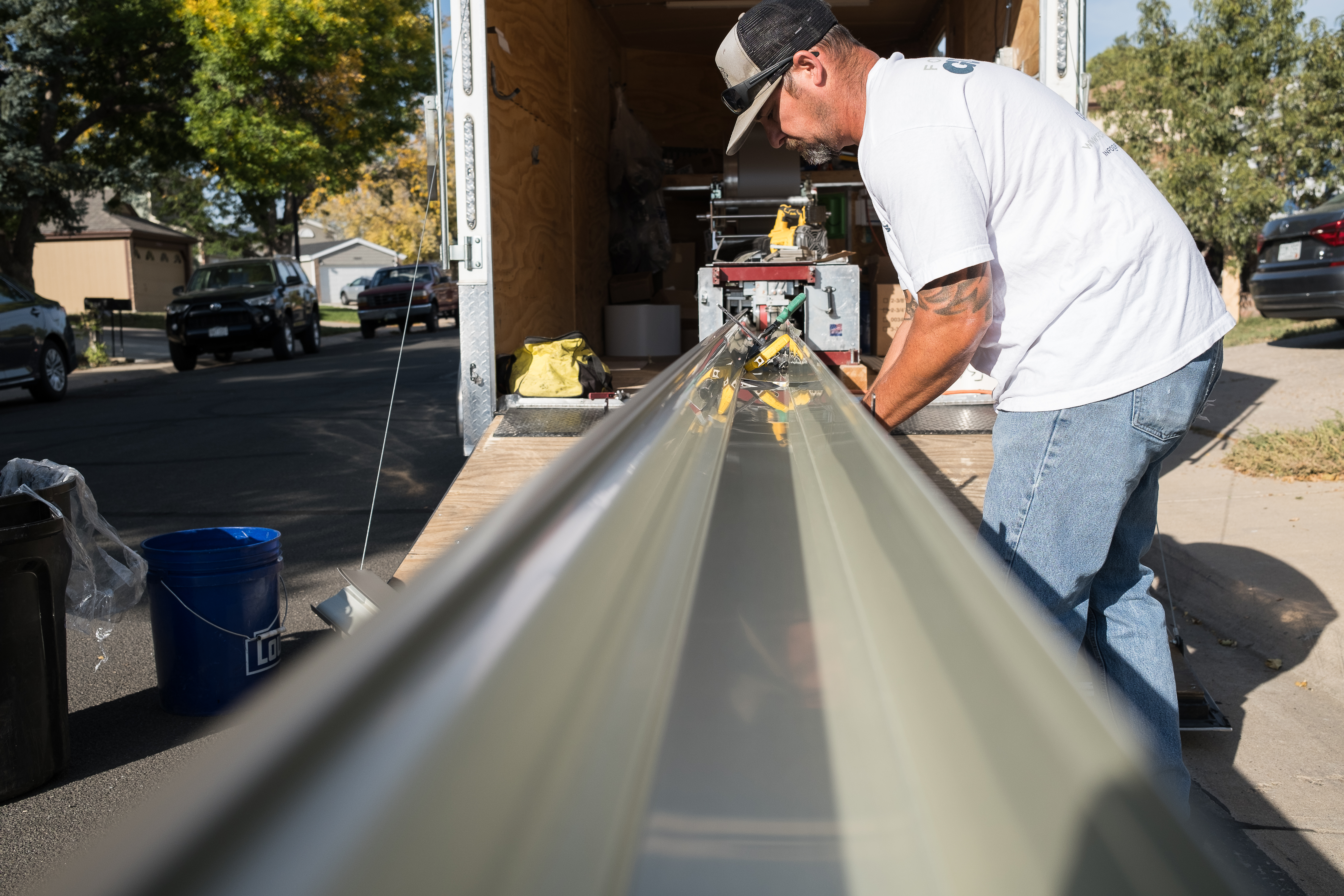 Fort Comfort Gutters crew carrying seamless gutter on a rooftop